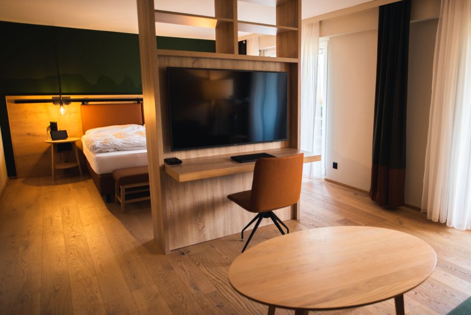 Lyst hotelværelse med seng og arbejdsbord